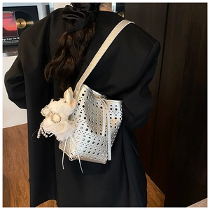 Détail du sac seau argenté découpé au laser avec breloque nœud en perles chic