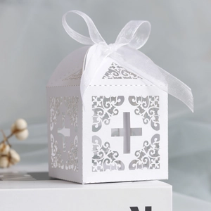 Close-up of laser-cut cross hollow gift box with white organza ribbon for weddings