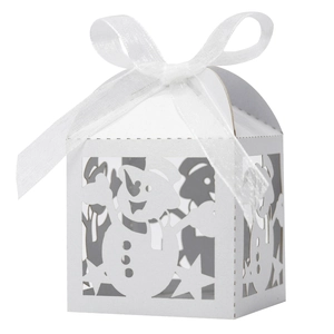 Close-up of white laser-cut Christmas candy box with snowman patterns and organza ribbon