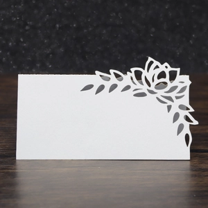Detailed close-up of white laser-cut floral pattern on a pearlescent paper table card