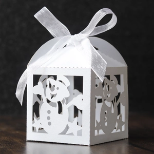 Detailed laser-cut white Christmas favor box with snowman motif and large white ribbon bow