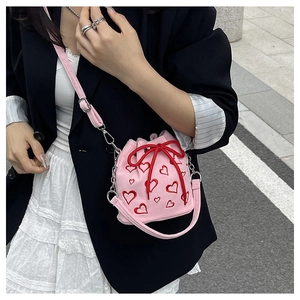Vue détaillée du sac seau en velours côtelé rose avec broderies cœurs et cordon
