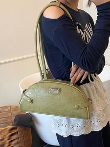 Grass green half-moon baguette bag with crocodile texture and silver metal plaque