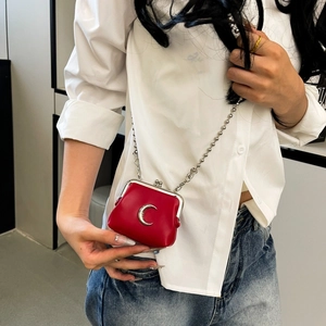 Mini red leather coin bag with silver chain and crescent moon detail on white shirt