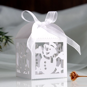 Macro shot of white Christmas candy box with laser-cut snowman and star patterns