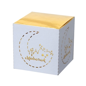 Detail of square white and gold Eid Mubarak favor box with laser-cut moon patterns