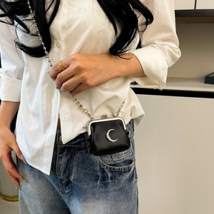 Detail view of mini black leather crossbody lipstick bag with silver crescent moon and chain