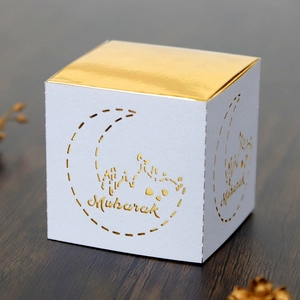 Detail view of a square Eid Mubarak candy box with gold foil moon and mosque cutouts