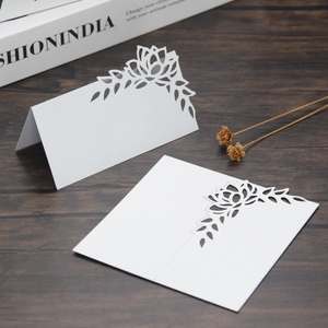 Detailed laser-cut floral design on white wedding place cards with elegant hollow patterns