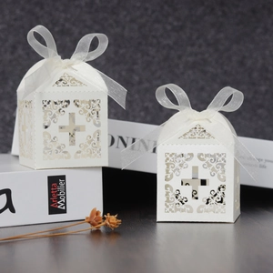 Ivory laser-cut favor box with cross pattern and white ribbon for weddings or baptisms