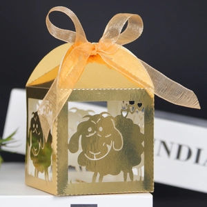 Detail of golden laser-cut sheep candy box with orange ribbon and mirror finish