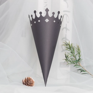 Detail of elegant black paper wedding cone with laser-cut crown edge on white tulle