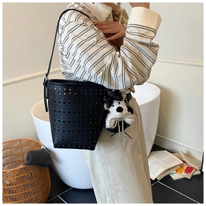 Détail du sac seau noir ajouré avec bandoulière longue et pendentif de chien mignon