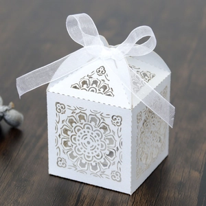 Gros plan des motifs mandala découpés au laser sur boîte cadeau en papier perlé blanc