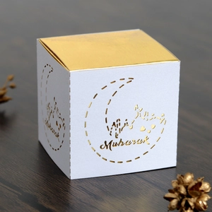 Detailed side view of Eid Mubarak gift box with gold moon pattern and hollowed design