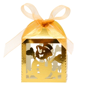 Close-up of golden Christmas snowman gift box with laser-cut patterns and ribbon