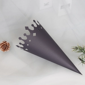 Detail of black crown-shaped paper cone with hollow diamond cutouts for wedding favors