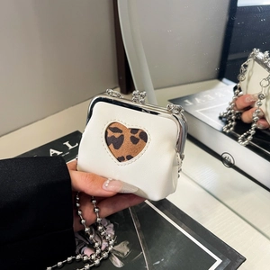 Detail of white leather mini coin purse with leopard heart cutout and silver ball chain