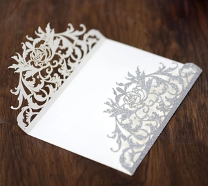 Detailed laser-cut white rose wedding invitation cover with elegant silver glitter finish