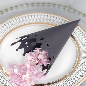 Close-up of black hollow crown paper cones filled with pink petals for wedding decor