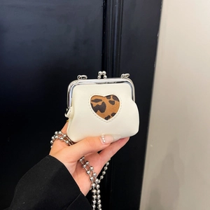 Close-up of mini crossbody bag with heart cutout, leopard print detail and silver chain