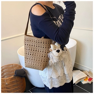 Détail du sac seau marron découpé au laser avec un joli pendentif ours en peluche blanc