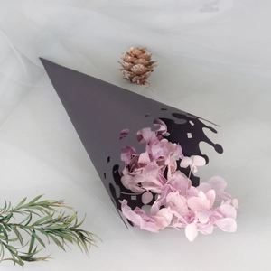 Hollow lace black paper cone for wedding flower petals on white tulle background