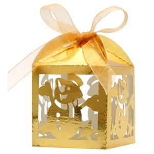 Macro detail of golden snowman hollow-out candy box with stars and a sheer ribbon bow