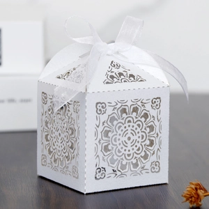 Détails de motif floral découpé au laser sur boîte de mariage blanche avec ruban