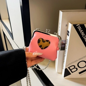 Detail of pink mini chain bag with heart cutout and leopard print lining close-up