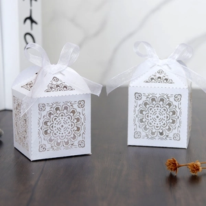 Gros plan de boîtes à bonbons de mariage découpées au laser avec des motifs floraux