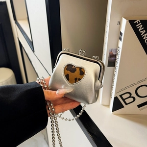 Mini silver crossbody bag featuring a leopard heart patch and spherical metal chain