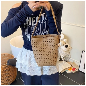 Détail du sac seau marron découpé au laser avec motif ajouré et breloque peluche