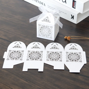 Détail de la boîte à bonbons de mariage découpée au laser avec motifs mandala et ruban blanc