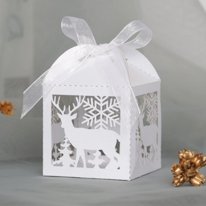 Detail der weißen lasergeschnittenen Weihnachtsdose mit Rentier- und Schneeflockenmuster