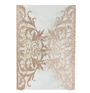 Macro detail of laser-cut rose gold glitter invitation cover with elegant floral patterns