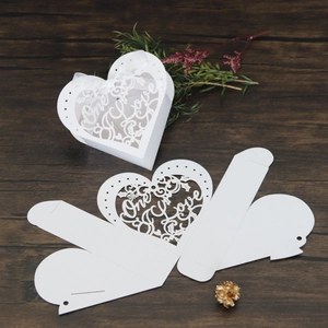 Detail of white laser-cut heart candy box with The One Love text and white ribbon bow