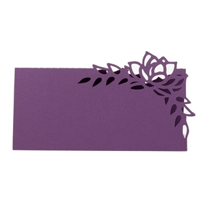 Close-up of laser-cut purple paper place card with floral hollow pattern and textured finish