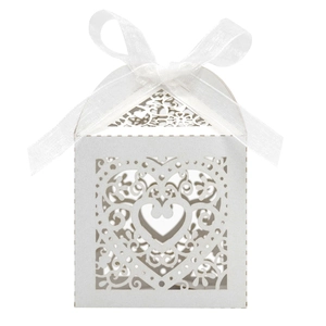 Macro detail of laser-cut heart pattern on pearlescent white candy box with ribbon