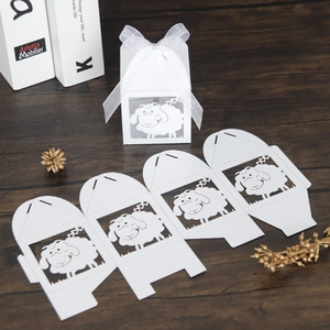 Laser-cut white sheep candy box with ribbon bow on a rustic wooden background