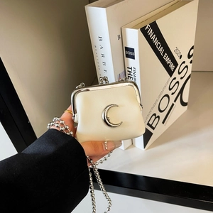 Detail of a creamy white leather mini kiss-lock bag with a silver crescent moon clasp
