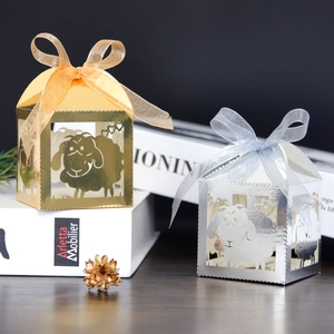 Detail of laser-cut sheep gift boxes in gold and silver with organza ribbon bows