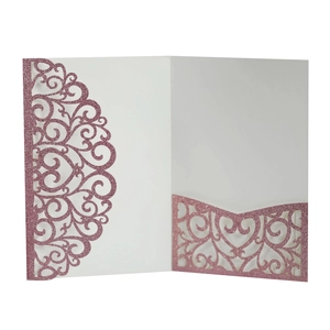 Detail of pink glitter laser-cut invitation with intricate heart vine pattern