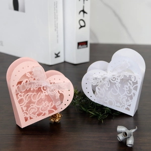 Detail of laser-cut heart candy box with Love motif and ribbon for wedding favors