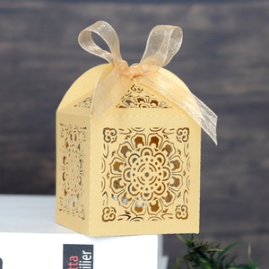 Détail de la boîte à bonbons de mariage dorée avec motif mandala et ruban champagne