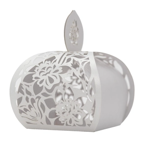 Macro detail of laser-cut white wedding favor box with intricate floral hollow pattern