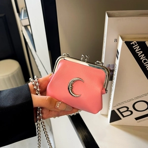 Close-up of pink mini crossbody bag with silver moon detail and metal chain strap