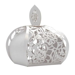 Macro detail of white laser-cut floral pattern on wedding favor candy box with pearl finish