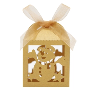 Macro detail of golden hollow candy box with laser-cut snowman and champagne ribbon