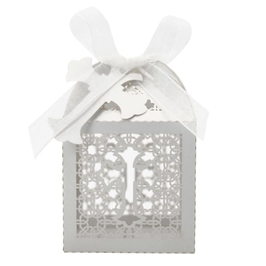 Close-up of laser-cut cross hollow pattern and white ribbon bow on wedding favor box